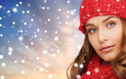 诞节,冬天人们的轻的女人戴着红色的帽子围巾雪的背景下戴着红色帽子围巾的女人雪的背景下图片