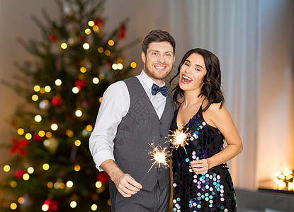 庆祝,派假日幸福的夫妇与火花诞树灯光背景诞晚会上闪闪发光的快乐夫妇图片