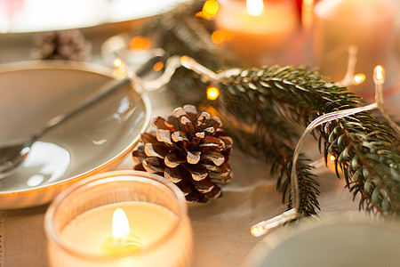诞节,假日装饰松果,冷杉树枝蜡烛燃烧桌子上,节日晚餐家里诞桌上燃烧的松果蜡烛图片