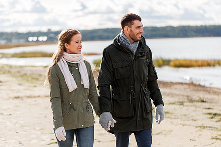 爱,关系人的微笑的夫妇沿着秋天的海滩散步,牵着手夫妇沿着秋天的海滩散步图片