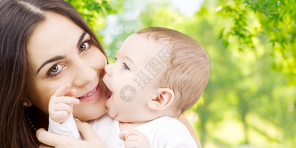 家庭母亲的快乐的微笑轻母亲与小婴儿超过绿色的自然背景母亲带着孩子绿色的自然背景下图片