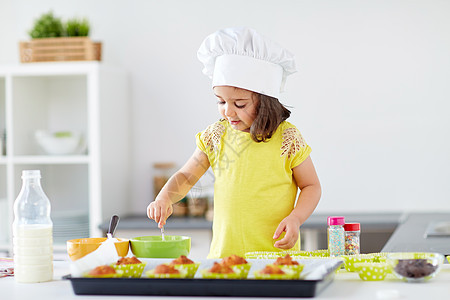 家庭,烹饪,烘焙人的小女孩厨师的口吃制作糊松饼纸杯蛋糕家里厨房厨师里的小女孩家烤松饼图片