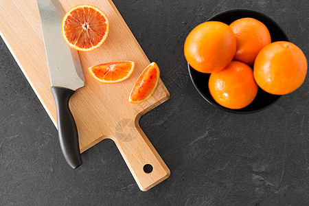 干水果食物,水果健康饮食血橙菜刀木制切割板切割板上的橘子刀背景