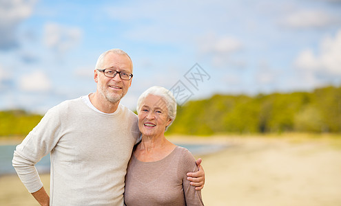 老,退休人们的快乐的老夫妇拥抱海滩背景快乐的老夫妇拥抱海滩背景图片