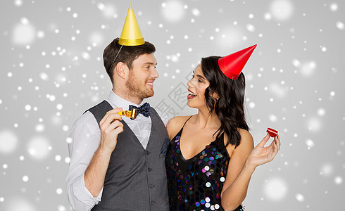 生日,庆祝假期快乐的夫妇与聚会奏帽子灰色背景雪上玩快乐的夫妻派奏者玩得开心图片