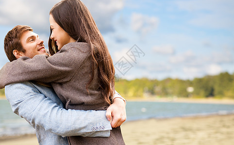 爱,关系人的快乐的十几岁的夫妇拥抱秋天的海滩背景快乐的轻夫妇拥抱秋天的海滩上图片