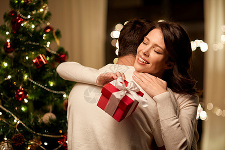 寒假人们的幸福的夫妇与诞礼物拥抱家里幸福的夫妇家里拥抱诞礼物图片
