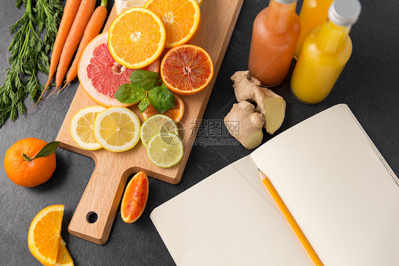 食物,健康饮食素食柑橘类水果木制切割板,瓶果汁笔记本石板桌把水果果汁笔记本放桌子上图片