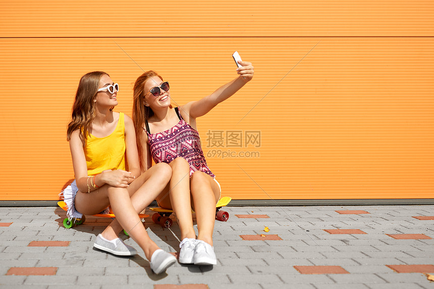 友谊,休闲技术快乐的十几岁女孩朋友与短滑板自拍智能手机城市街道夏天十几岁的女孩带着滑板自拍图片