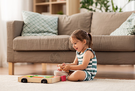 童人的快乐的三岁女婴玩玩具块家快乐的女婴家里玩玩具积木图片