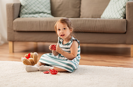 童人的快乐的三岁女婴玩茶玩具陶器泰迪熊家里小女孩家玩玩具茶具背景图片