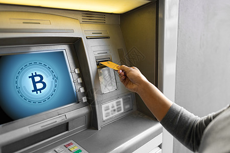 金融,加密货币技术密切妇女手插入银行卡ATM机与比特币图标屏幕上妇女插入卡ATM机图片