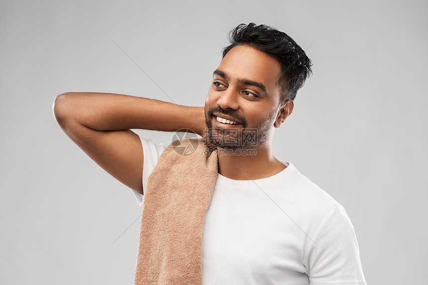 修饰人的微笑的印度男子与浴巾灰色的背景微笑的印度男人带着毛巾灰色的背景上图片