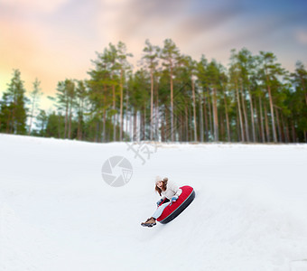 冬天,休闲娱乐活动的快乐的十几岁女孩滑下雪管下山快乐的少女雪管上滑下山背景图片