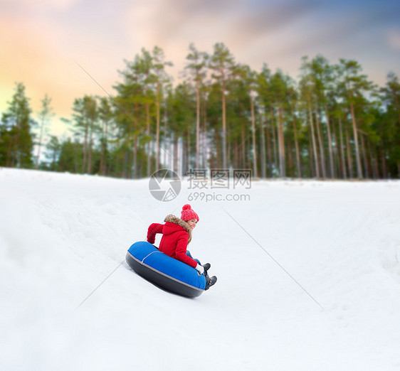 冬天,休闲娱乐活动的快乐的十几岁女孩滑下雪管下山快乐的少女雪管上滑下山图片