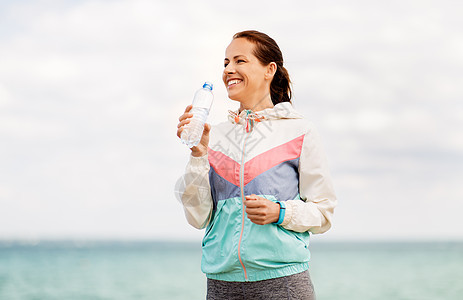 健身,运动健康的生活方式妇女海边锻炼后饮水女人海边锻炼后喝水图片