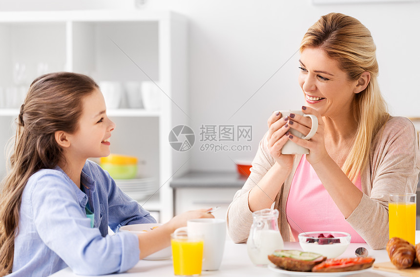 食物,健康饮食,家庭人的快乐的母亲女儿家里的厨房吃早餐快乐的母亲女儿家吃早餐图片