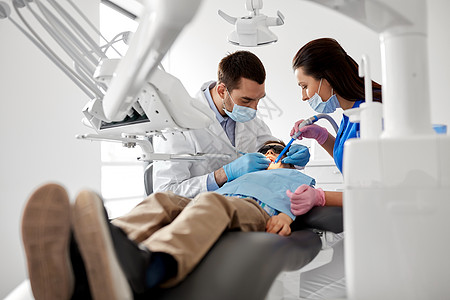 医学,牙科医疗牙科医生助理与牙科钻唾液喷射器治疗儿童患者牙齿牙科诊所牙医牙科诊所治疗儿童牙齿图片