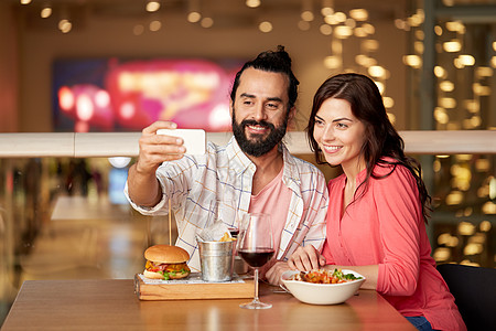 休闲,技术人的快乐的夫妇餐厅吃午饭用智能手机自拍夫妇餐厅用智能手机自拍图片
