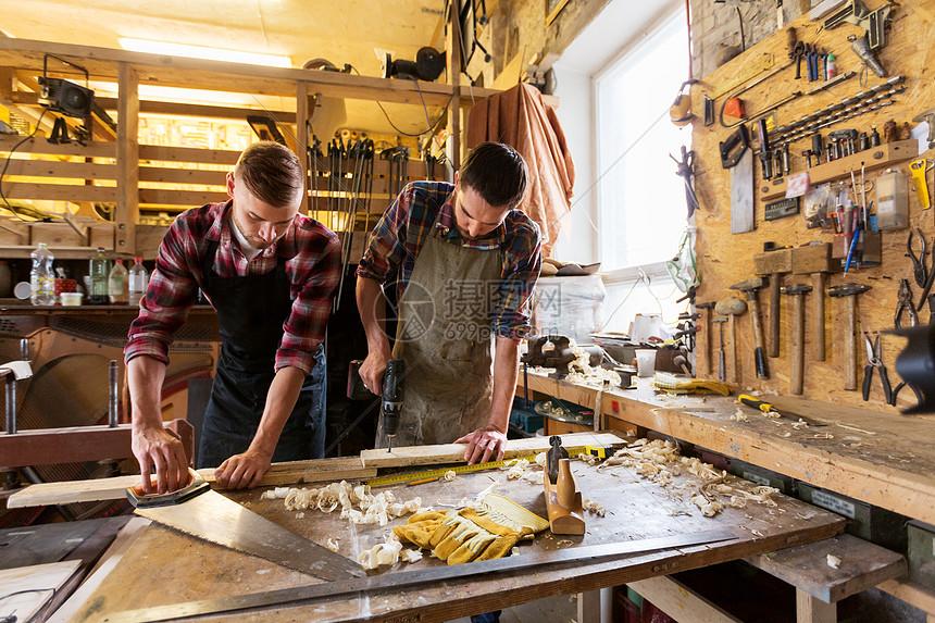 专业,木工,木工人的两个木匠与木板,锯电钻车间工作木匠车间用木板工作图片