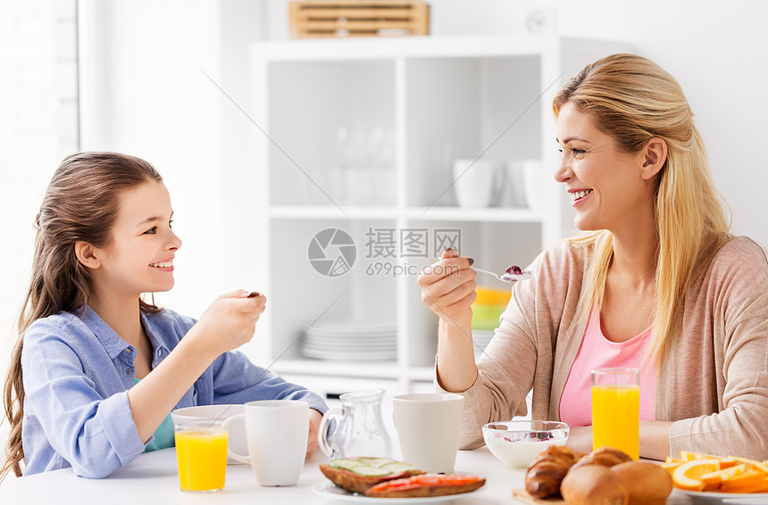 食物,健康饮食,家庭人的快乐的母亲女儿家里的厨房吃早餐快乐的母亲女儿家吃早餐图片