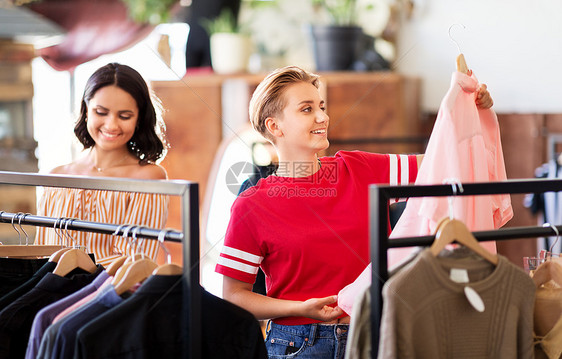 销售,购物,时尚人们的快乐的轻妇女选择衣服老式服装店女人老式服装店挑选衣服图片