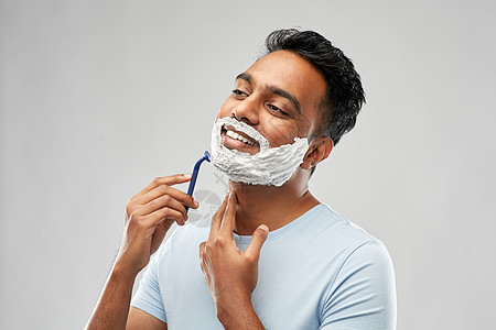 美容人的轻的印度男子剃须胡须与手动剃须刀刀片灰色背景印度男人用剃须刀刮胡子图片