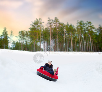 冬天,休闲娱乐活动的快乐的十几岁女孩滑下雪管下山快乐的少女雪管上滑下山背景图片