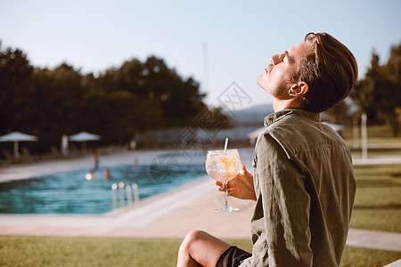 男人游泳池附近喝鸡尾酒春天夏天图片