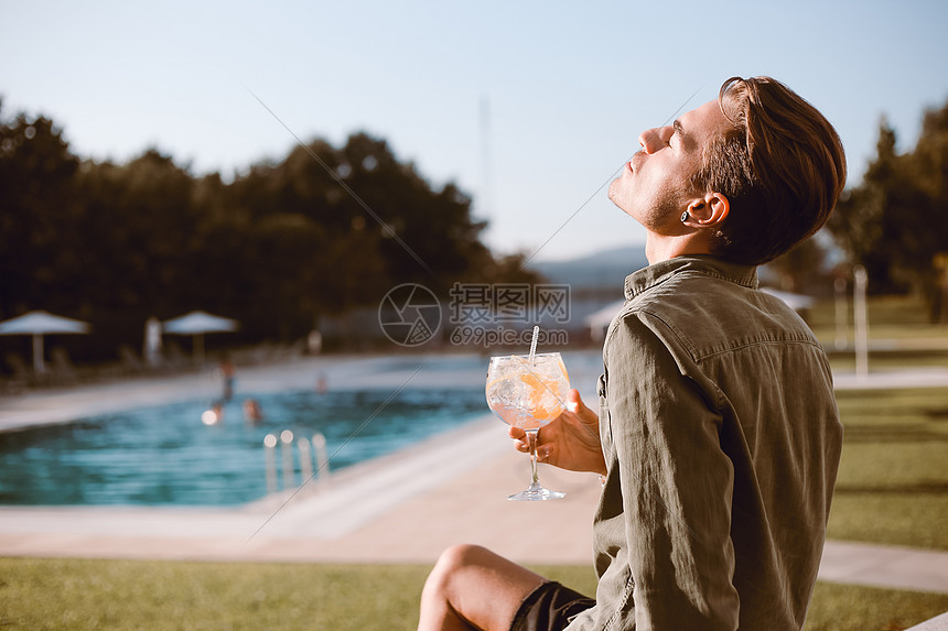 男人游泳池附近喝鸡尾酒春天夏天图片