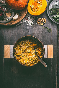俯瞰美味的南瓜菜与米饭烹饪锅黑暗的乡村厨房桌子背景,顶部的视图南瓜烩饭秋季季节乡村食品图片