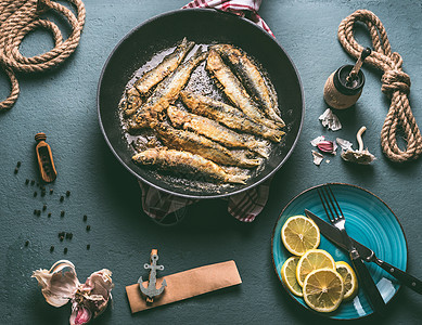 油炸沙丁鱼煎锅配料美味的海鲜烹饪鱼的烹饪准备,顶部视图背景图片