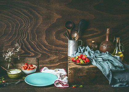 空蓝盘子深色的乡村木制厨房桌子上,碗里草莓酸奶乡村风格的食物背景,静物,正观为您的,食谱,文本产品的地方图片