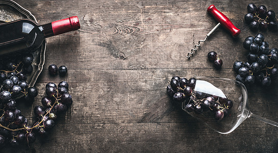 红酒背景与瓶子瓶塞,葡萄酒杯黑暗的老式木制,顶部视图,框架图片