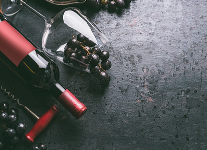 红酒背景酒瓶与老式瓶塞螺丝,璃葡萄复古黑色背景,顶部视图图片