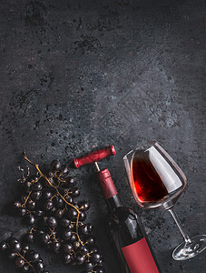 红酒瓶与老式开瓶器,璃葡萄复古黑色背景,顶部视图图片