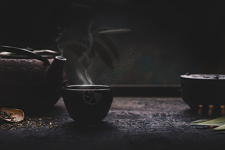 深色茶背景,黑铁亚洲茶壶热茶杯与蒸汽桌子上为您的正宗的复古风格传统的茶道安排图片