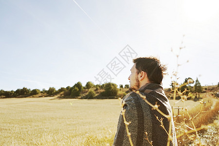 个轻人后站着,条黄色田野的小径上平静地享受着的秋日,背光来自蓝天图片