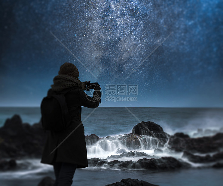 个女人正海洋上拍摄片星空天体摄影图片