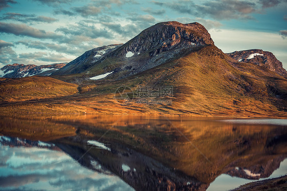 挪威湖里倒影的山脉秋红电影风格的颜色图片