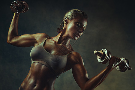 强壮的女健美运动员站墙上的背景上戴着哑铃古代青铜色的效果图片