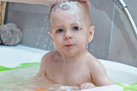 妈妈用洗发水洗澡时洗婴儿背景图片
