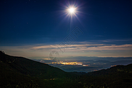 山上灯光城镇的明月夜景图片