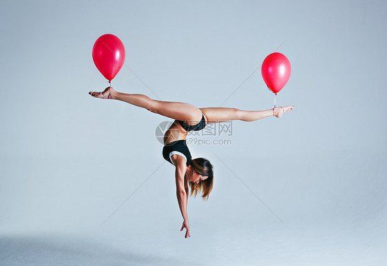 轻的体育女气球上倒立着劈叉姿势轻盈的图片