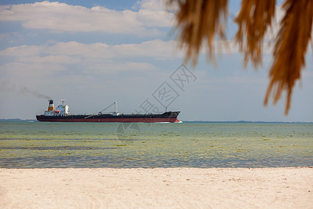 油轮航行空的热带海滩与棕榈树白沙图片