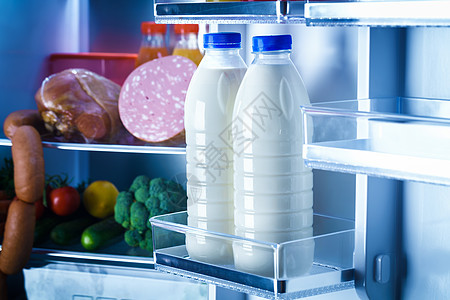 打开装满食物的冰箱把注意力集中冰箱里的牛奶瓶上图片