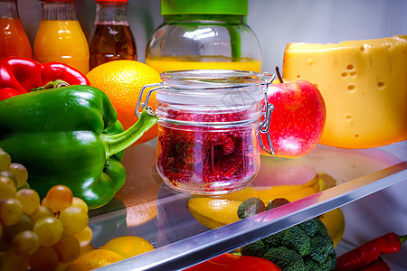 新鲜的覆盆子放璃瓶里,放架子上,打开冰箱健康的食物背景图片