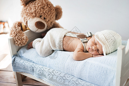 新生儿泰迪熊睡觉背景图片
