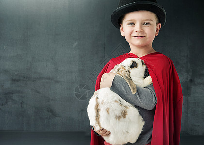 小魔术师抱着只神奇的兔子图片