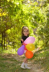 森林里五颜六色气球的小女孩图片